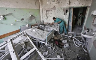 A_Palestinian_medic_inspects_a_damaged_room_at_Al-Aqsa_hospital
