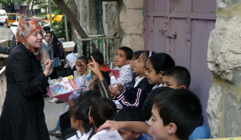 A school teacher from Qurtuba primary school giving a science class near the checkpointat the Northern entrance of al-Shuhada’ street – October 2011, Al-Haq© Qurduba2