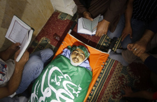 449329-palestinians-read-the-koran-next-to-the-body-of-munir-al-badarin-durin