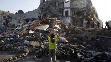 Palestinian children stand in the rubble left after an Israeli strike on a house in Gaza City, on Nov. 20. [Credit : Hatem Moussa / AP]